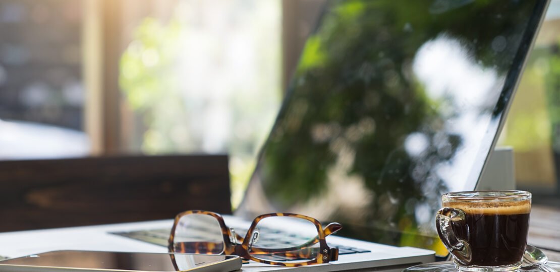 Office workplace with laptop and glasses on wood table